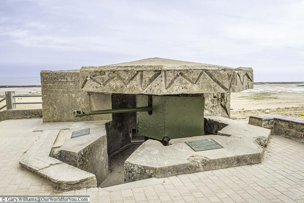 An artillery gun, mounted in a pillbox, at the edge of 'Juno' beach in Normandy.