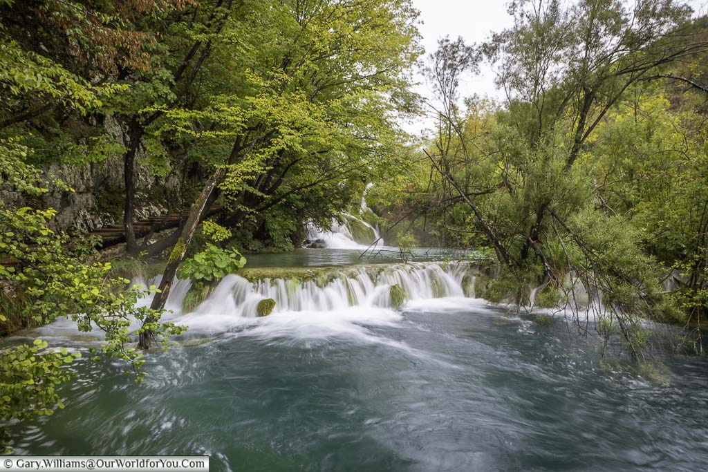 water flowing over a series of shallow drops leading to one of the plitvice lakes in croatia