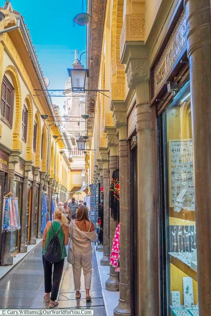 A couple walking down a narrow lane that was once the former arab silk market towards granada cathedral in andulucia, spain