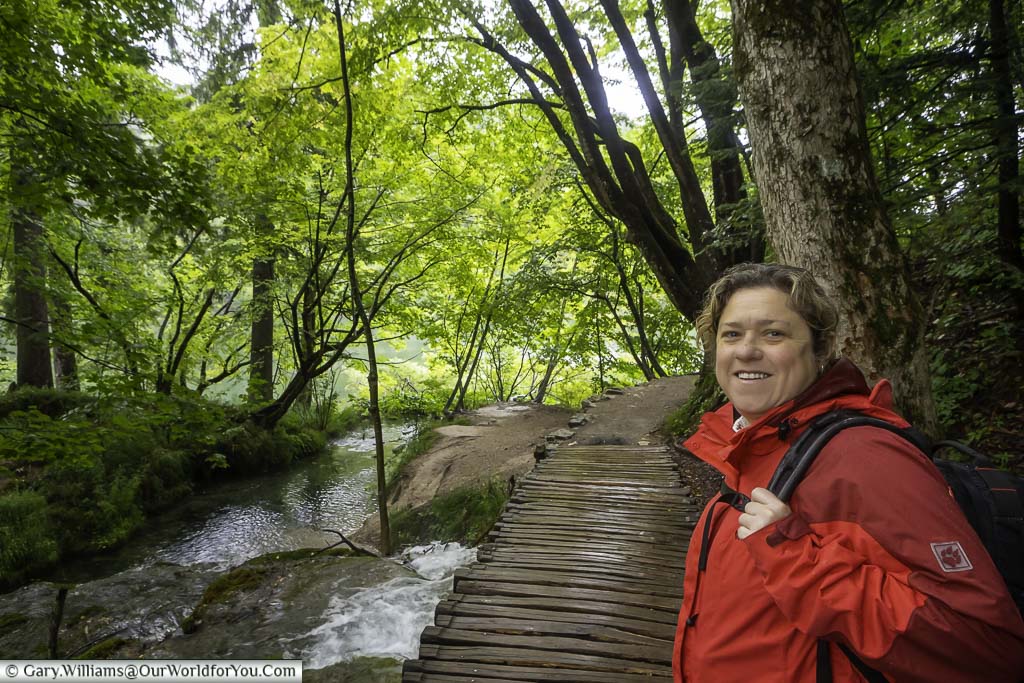Janis looking back at the camera before taking a small wooden pathway through the plitvice lakes national park in croatia