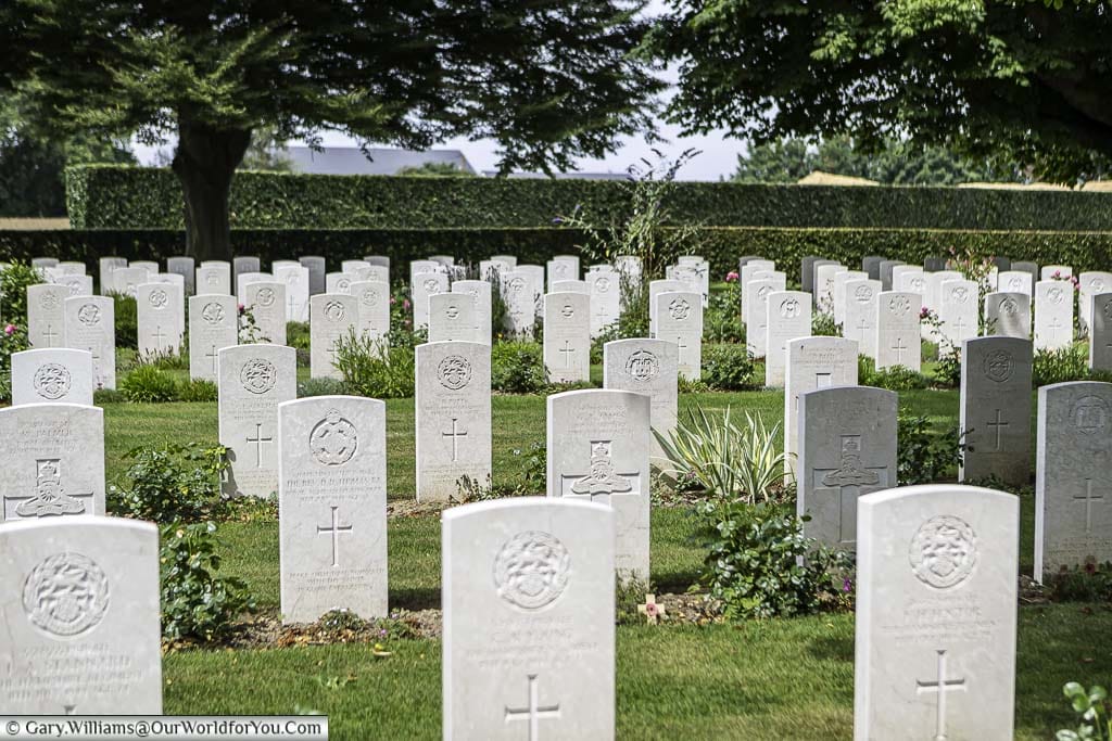 Row upon row of the white portland stone headstones of the fallen Commonwealth Servicemen in the Bayeaux British military cemetery.