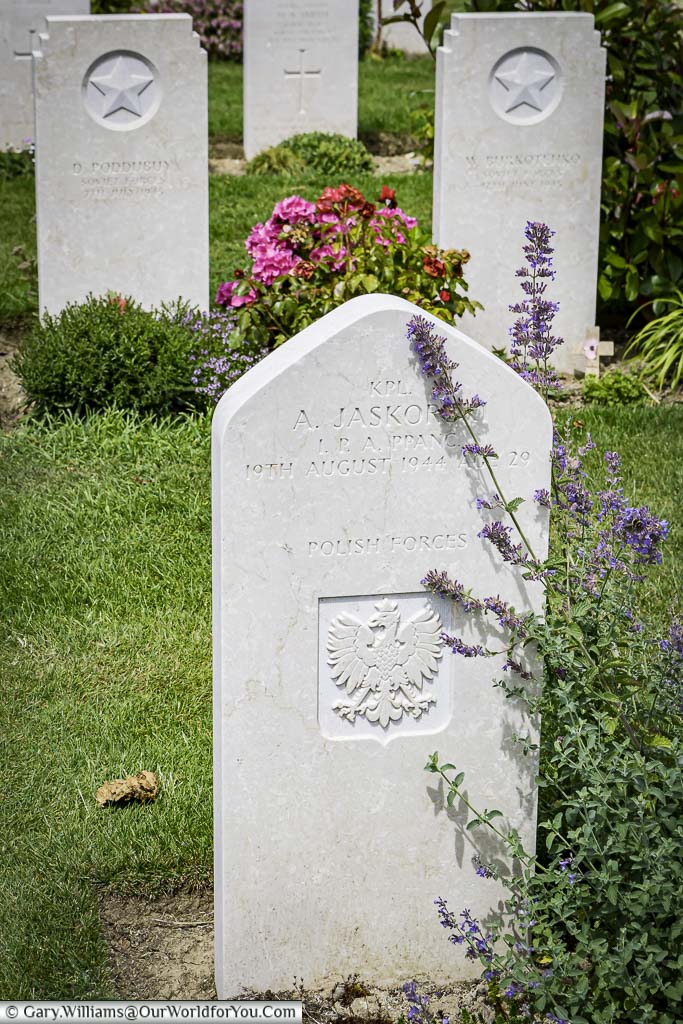 A headstone, in Bayeux Commonwealth Military Cemetery, to a Polish soldier, constructed of the same stone, but with a soft pointed top.