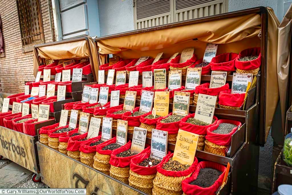 a market stall with four rows of spices and herbs on the street side in granada in andulucia, spain