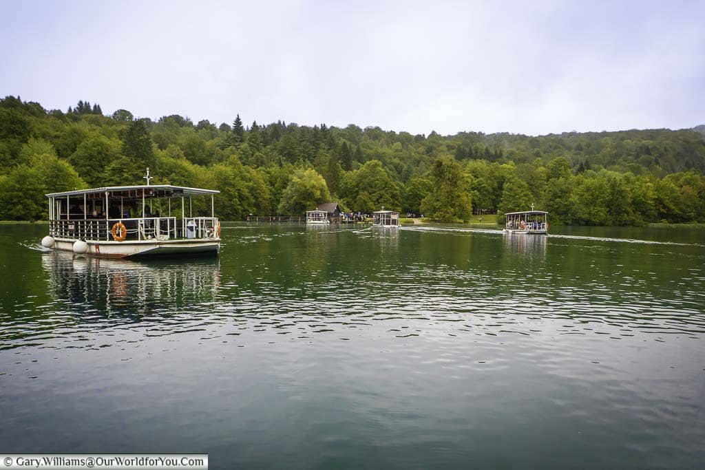 Small, basic ferry boats transporting people from one side to the other of one of the plitvice lakes in croatia