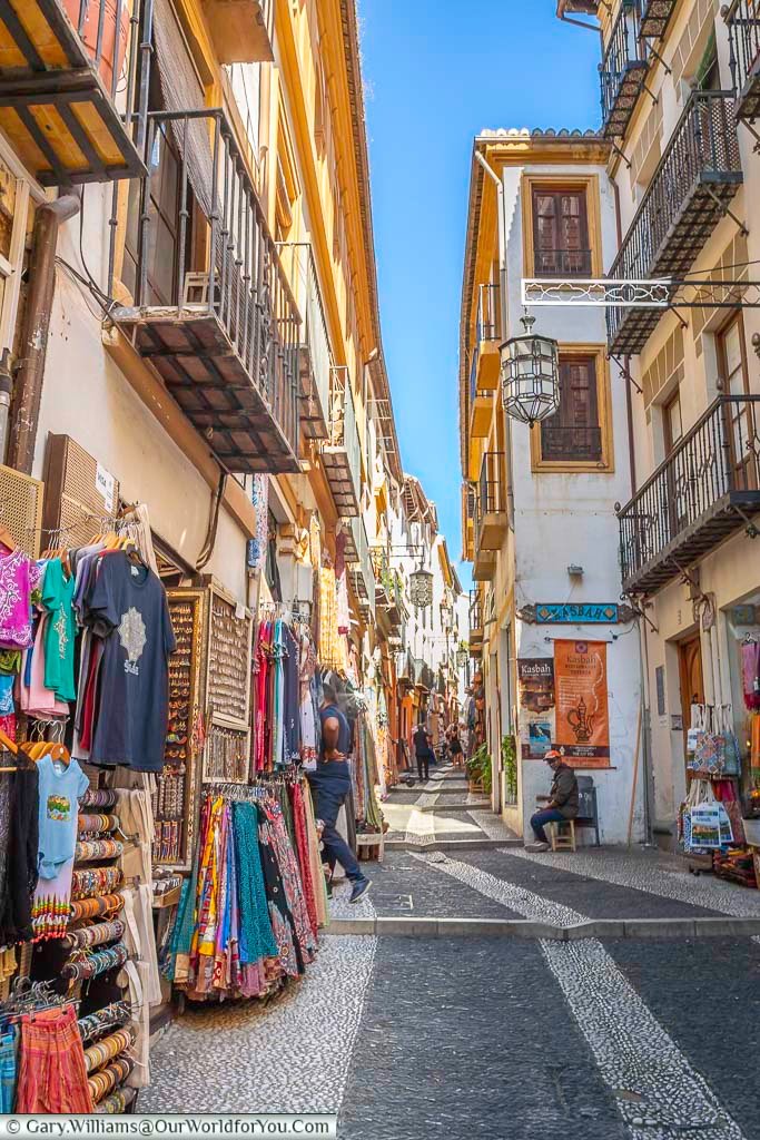 the view along the narrow calle calderia nueva with is individual traders in granada, southern spain