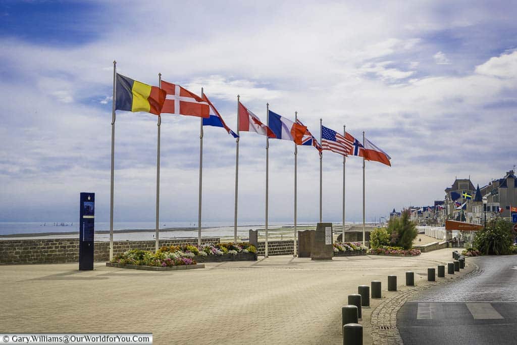 9 flagpoles, with 9 different allied flags fluttering in the wind at Courseulles-sur-Mer, overlooking 'Juno' beach in Normandy
