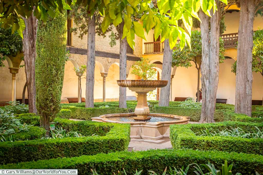 A fountain in the tree lined lindaraja courtyard garden in the alhambra palace in granada, spain
