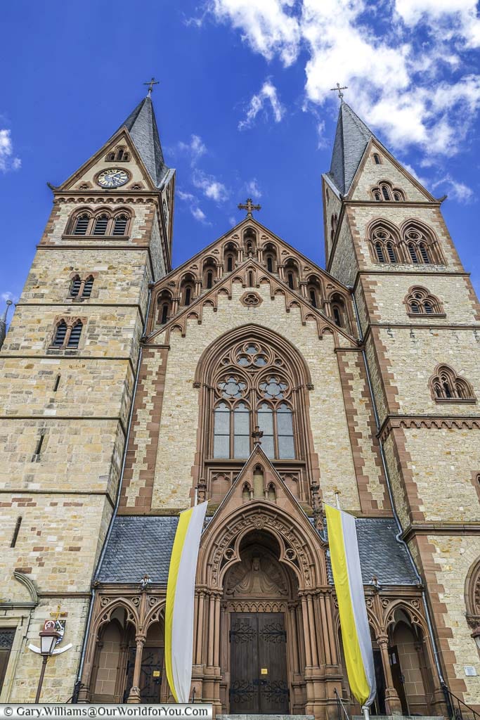 Looking up at the front of the Cathedral of Bergstraße with its yellow brickwork and deep red stonework.