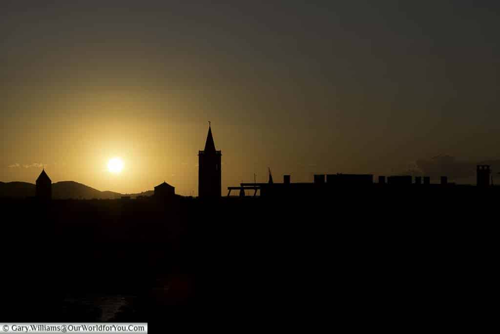 A silhouetted skyline of Zadar, Croatia, against a golden sunset from our apartment building.