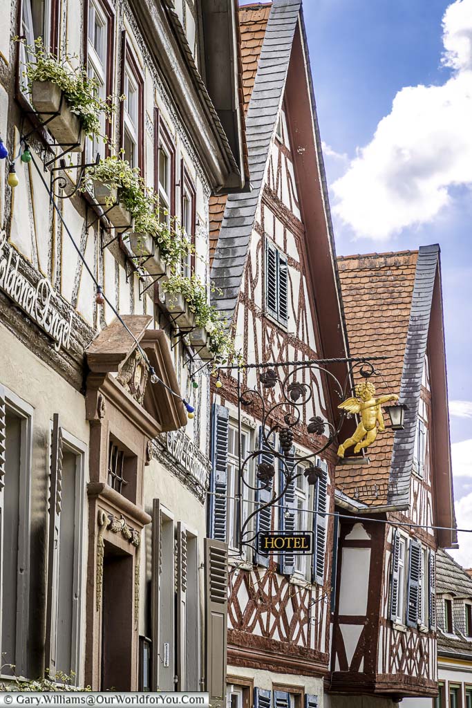 A roofline view of the gable ends of the building surrounding market platz. Here you can see a wrought iron sign featuring Golden Angel of a local hotel.