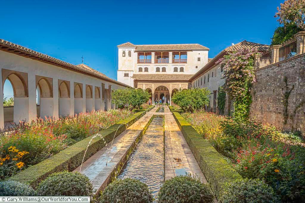 Water running along a central chanel in the patio de la acequia in the generalife, the gardens within the alhambra palace in granada, southern spain