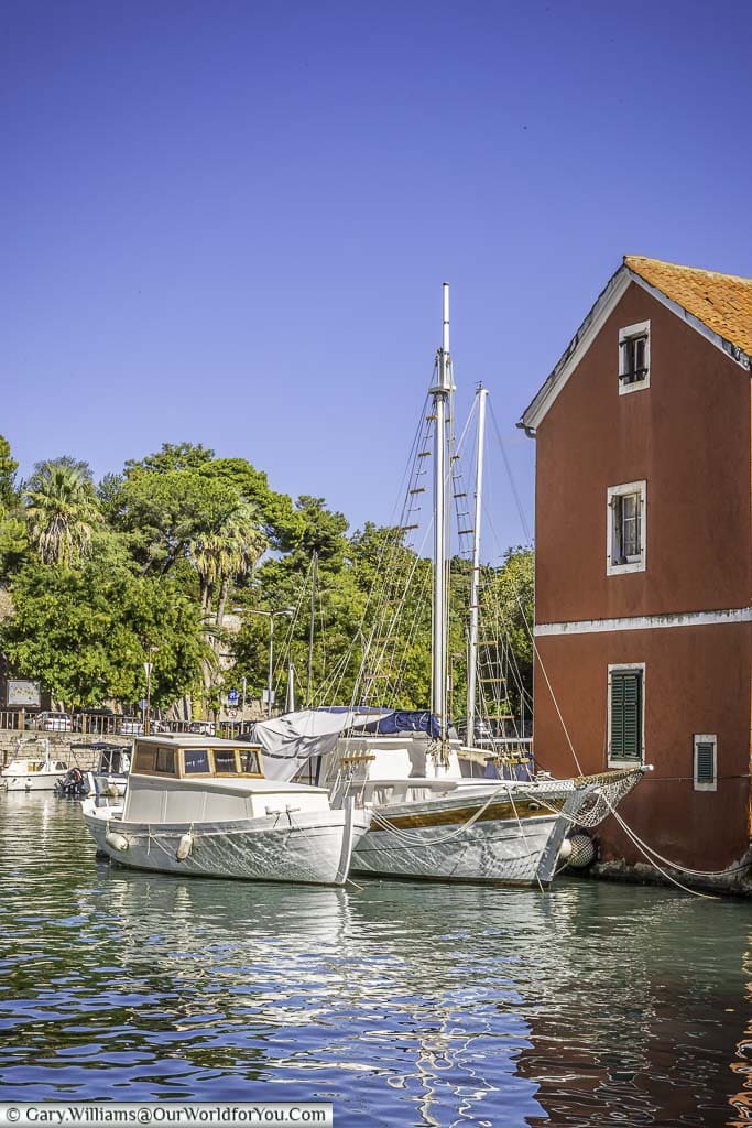 Two white sailing boats mooring in the small picturesque port of Fosa in Zadar.
