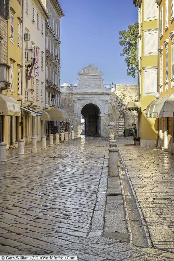 A cobbled lane between five-storey homes that leads towards Zadar's old Sea Gate