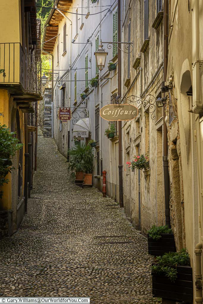 A narrow cobbled lane line with shops and homes in orta san giulio on the shores of lake orta, italy