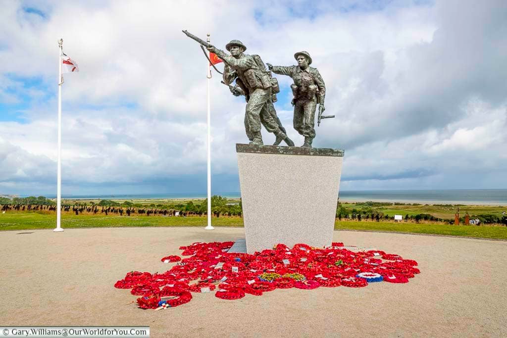 A close-up of the statue of three charging soldiers heading up from gold beach on the d-day landing at the british normandy memorial in normandy, france