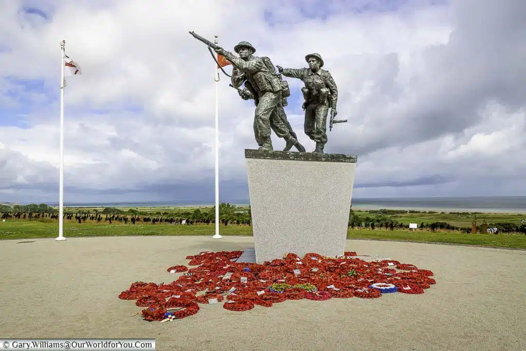 A close-up of the statue of three charging soldiers heading up from gold beach on the d-day landing at the british normandy memorial in normandy, france