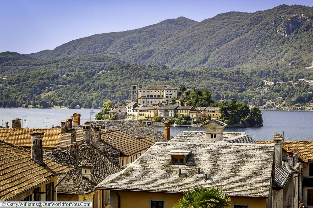 A view across the roof tops of orta san giulio on the shores of lake orta to the small island of Isola San Giulio