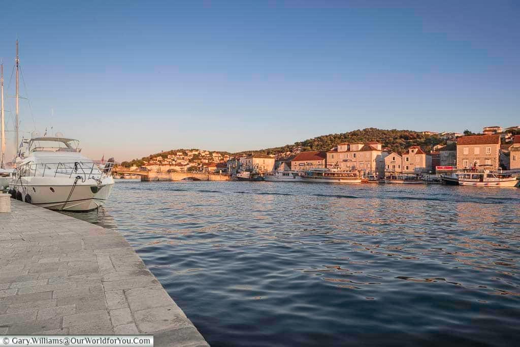 A cruiser moored against the water's edge at dusk on the riva in trogir, croatia