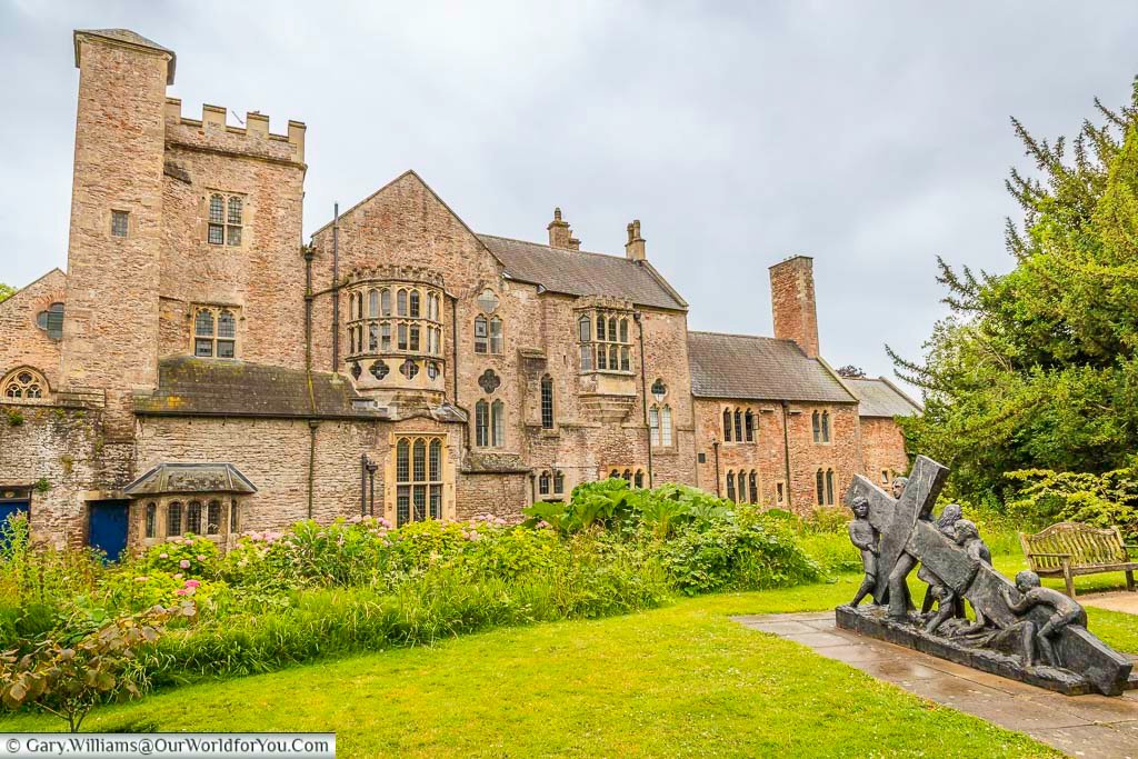 A statue of people dragging a large cross in the gardens of the archbishop’s palace in wells, somerset