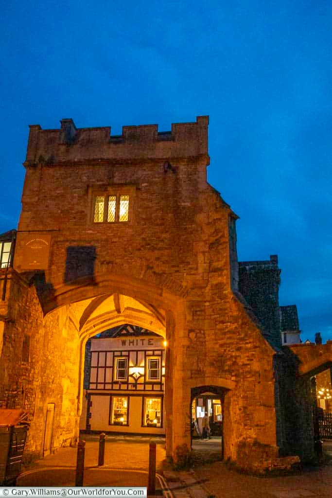 Brown's gatehouse, as seen from the cathedral green after the sun has gone with the white hart inn in the background