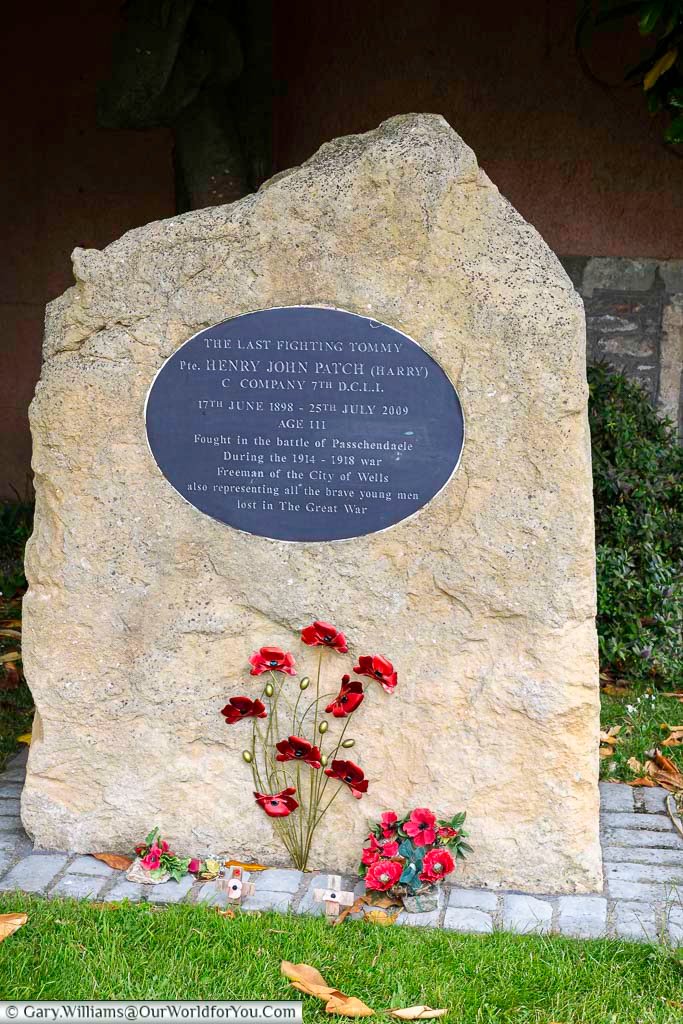 A stone memorial to henry john patch who dies aged 111 years old, known as the last fighting tommy on the edge of wells cathedral green