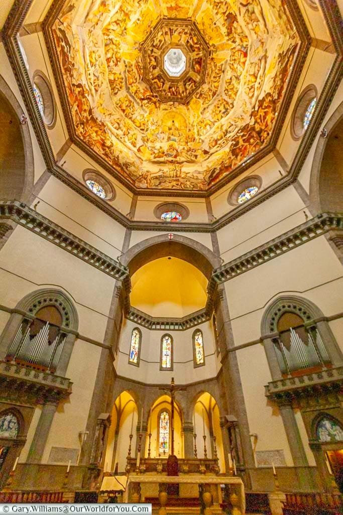 inside the duomo of florence, looking up at the highly decorated dome