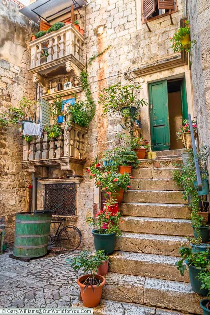 Stone steps, lined with potted plants leading to an apartment in the heart of old trogir, croatia