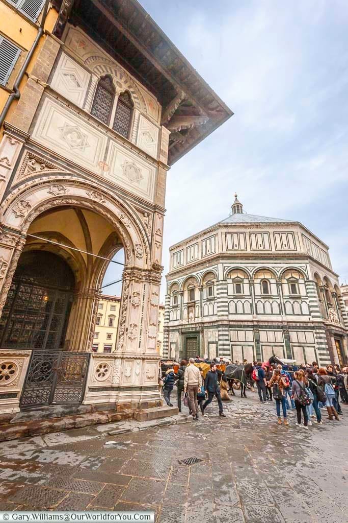 A busy street scene featuring the iconic baptistery of saint john in the centre of florence in italy