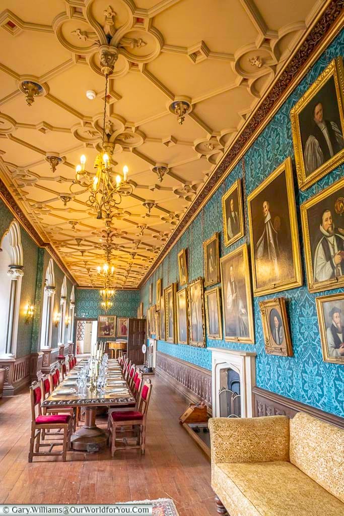 A wall of portraits of bishops line one side of the long gallery, with a large dinning table taking centre stage in the archbishop’s palace in wells, somerset