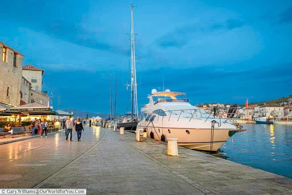 Boats moored against the water's edge at dusk on the riva in trogir, croatia