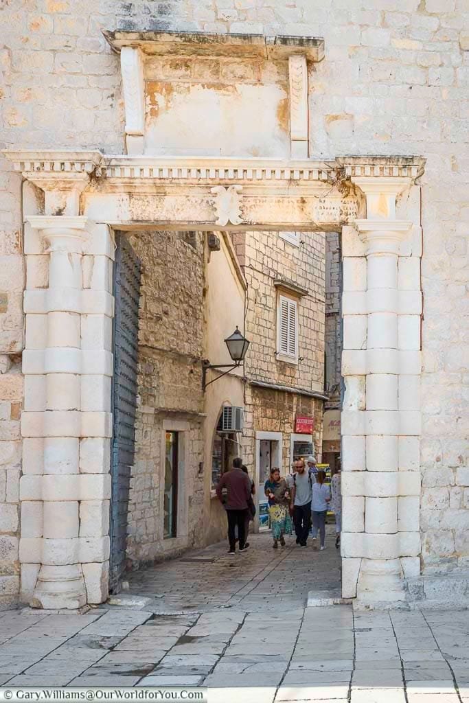 The stone south gate in Trogir's city walls leading to the cobbled lanes at its heart