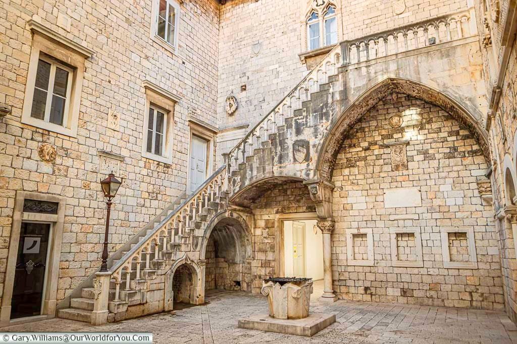 a stone staircase in the courtyard of the town hall in historic trogir, croatia