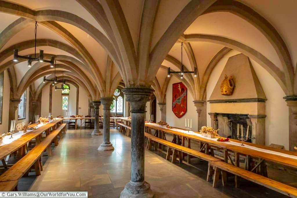 The undercroft in the archbishop’s palace in wells, somerset, laid out for a medieval banquet.