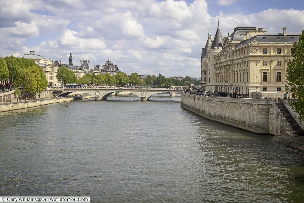The view along the River Seine, on a bright day in Paris, from Pont Neuf towards the Pont au Change with the impressive Supreme Court on the right-hand side sitting on the Île de la Cité.