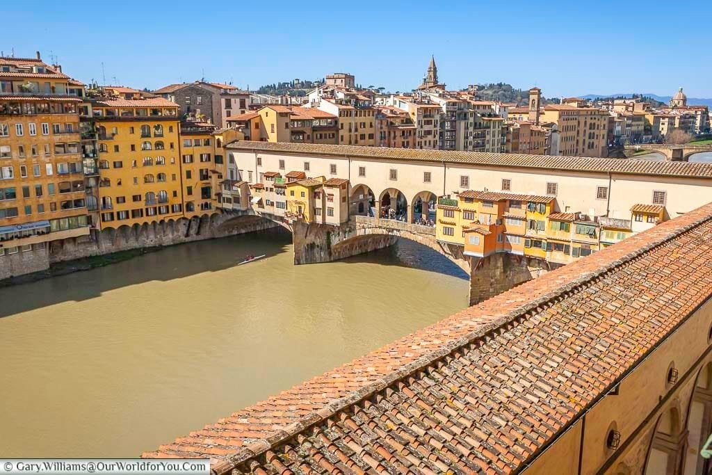 The view from our hotel room of the vasari corridor as it makes its way along the river arno and makes its way over the ponte vecchio in florence, italy