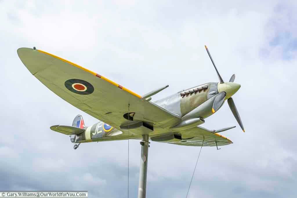 A full-size replica of a spitfire world war two fighter plane on a pole at the secret spitfires memorial in salisbury