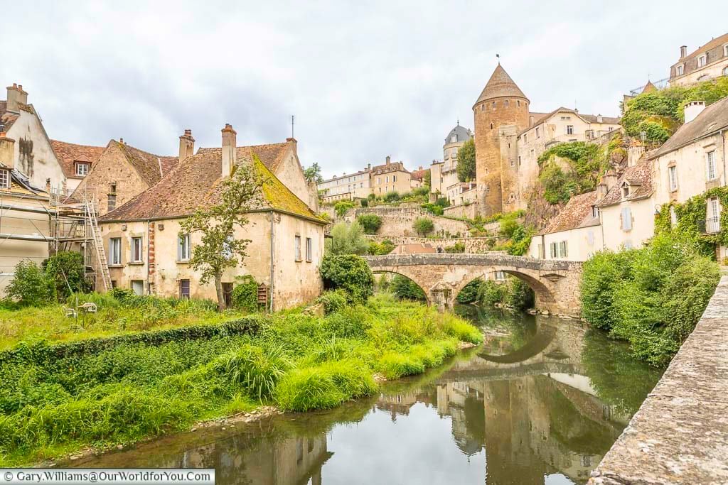 The idyllic scene of the historic town of semure-en-auxois as seen from the river armançon towards the pinard bridge