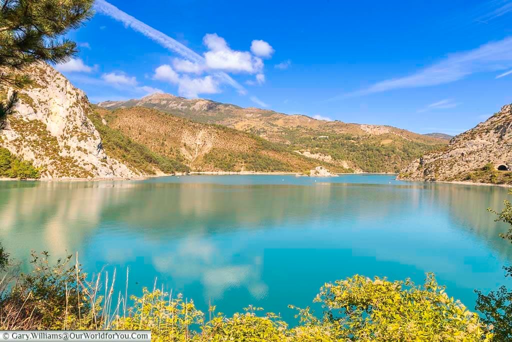 A roadside view of the deep blue waters of the lac de castillion nested between rocky hills in the verdon national park in the alpes-de-haute-provence region of france