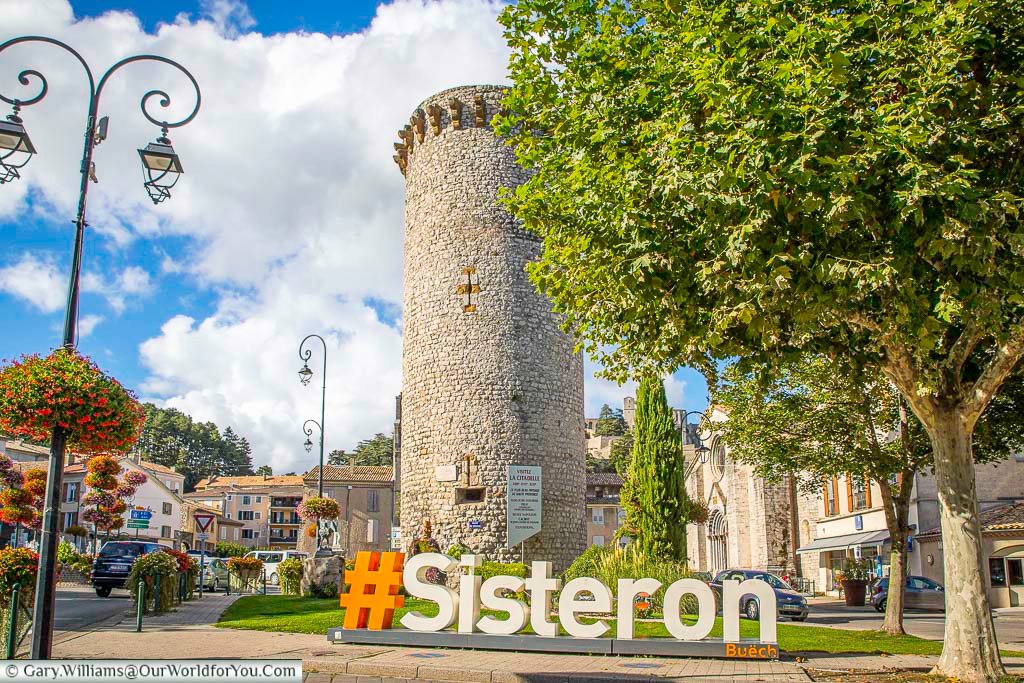 The hashtag sisteron sign in front of the medieval stone devil's watch town in the alpes-de-haute-provence region of france