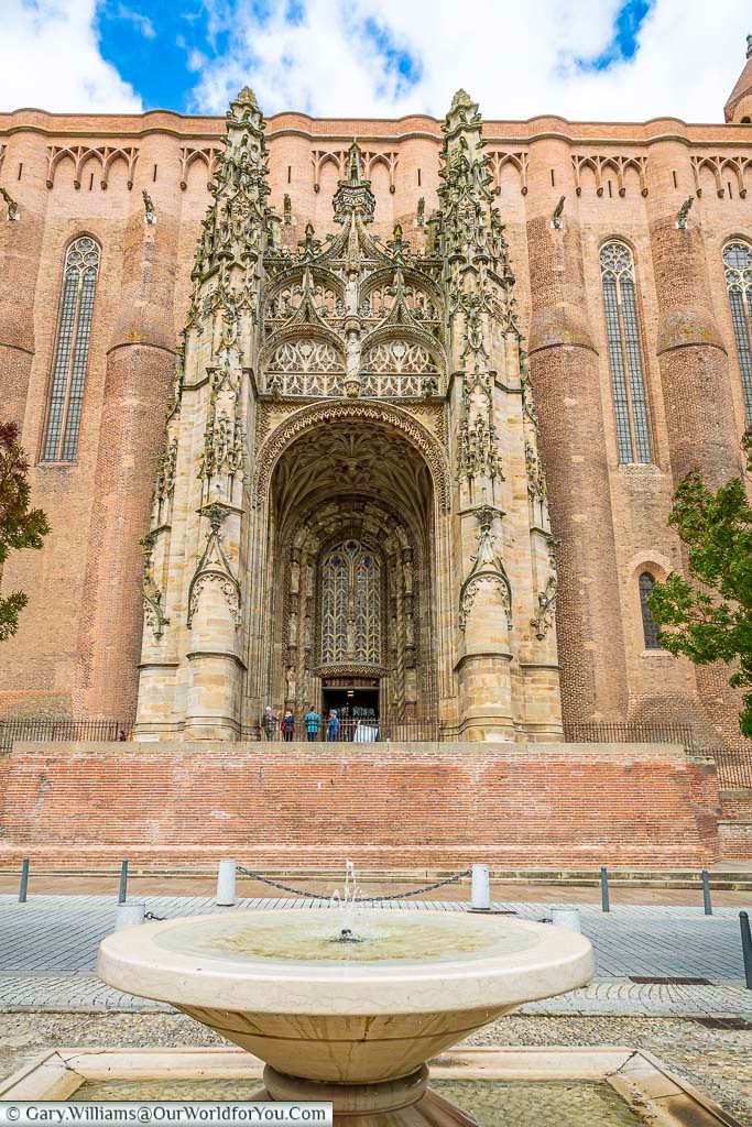 A fountain opposite the ornate entrance to albi cathedral in the occitania region of southern france