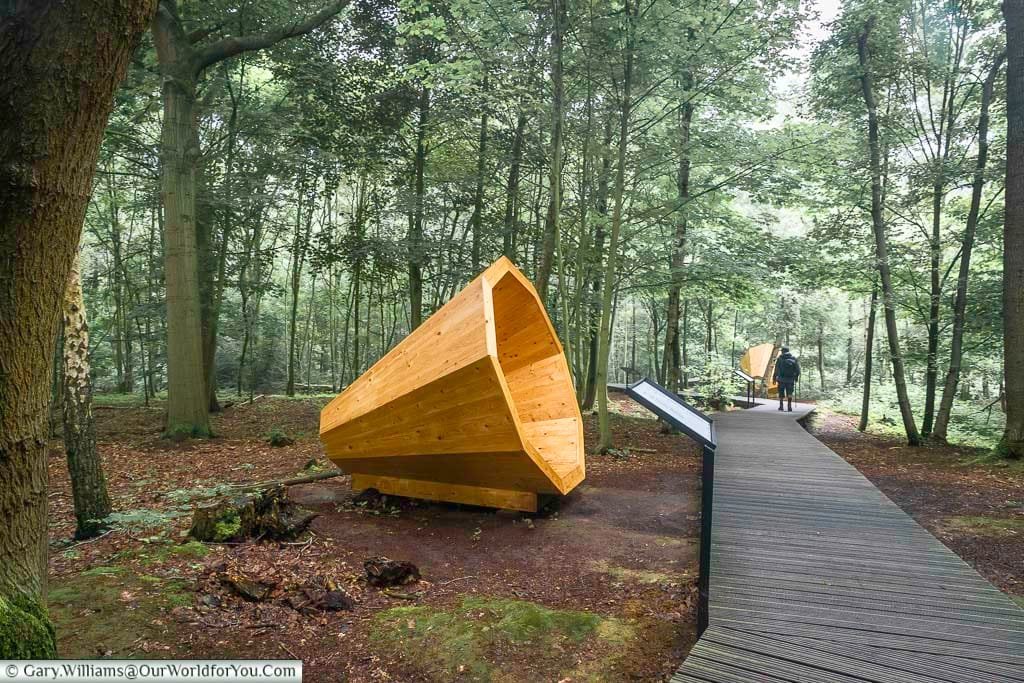 A wooden path past a giant cone shaped wooden speaker in the woodland around the bluff in the battlefields of belgium