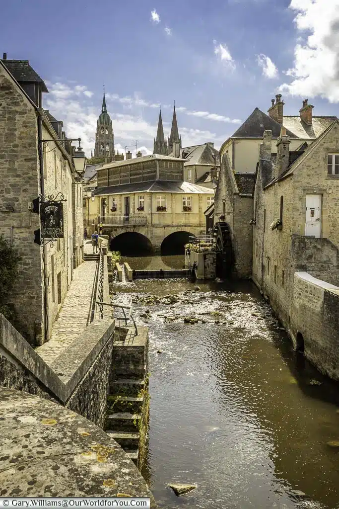 the view along the river aure to the bayeux watermill withe the cathedral in the background in bayeux, normandy, france