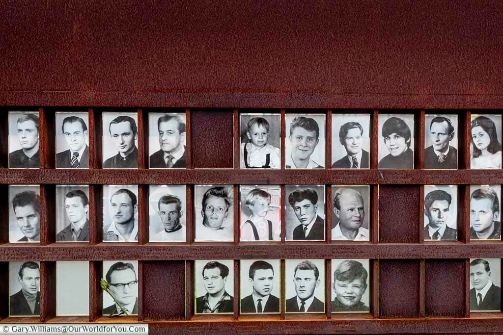 An oxidised metal memorial picture frame of 3 rows of portraits of those who died trying to cross the Berlin Wall.