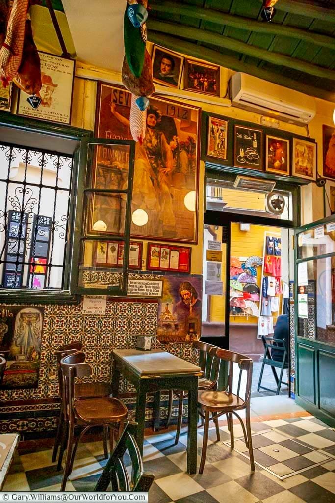 Inside the traditional Casa Placido with simple chairs & marble tabletops. The walls are lined with framed pictures of flamenco artists & matadors.