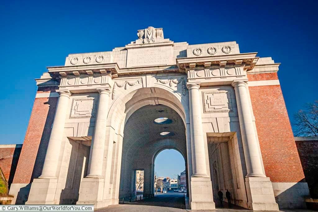 Looking through the Menin Gate in the Belgium town of Ypres on a bright sunny day under deep blue skies