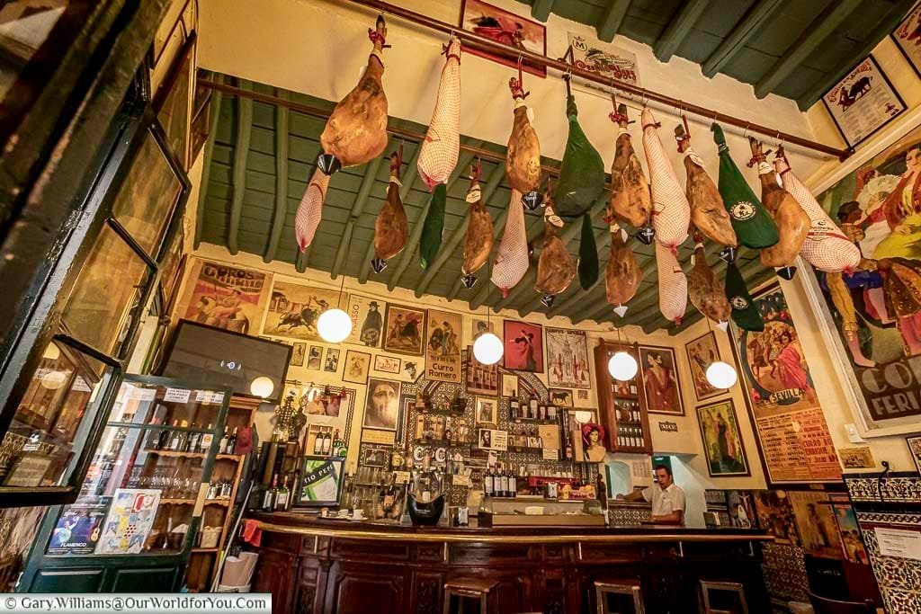 The counter of Casa Placido, a traditional bar with hams hanging from the roof.