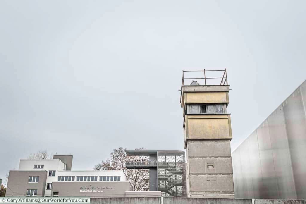 A watchtower in no-man's-land against a grey sky.