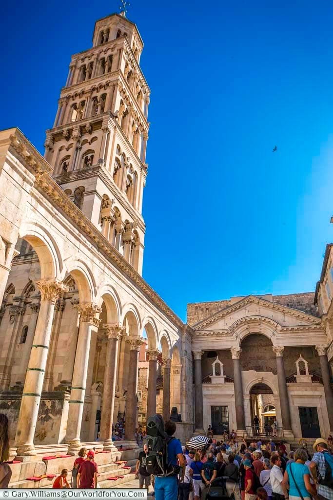 Inside the Diocletian Palace in Split looking up at the Roman Peristyle against bright blue skies.