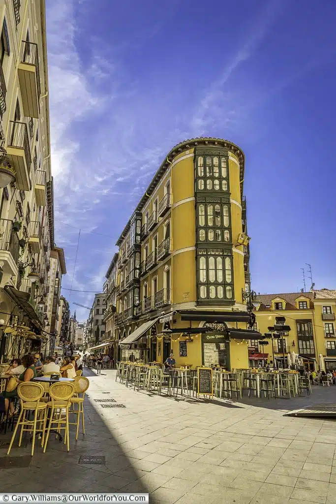tables and chairs in front of bars and restaurants on calle cascajares in valladolid, spain