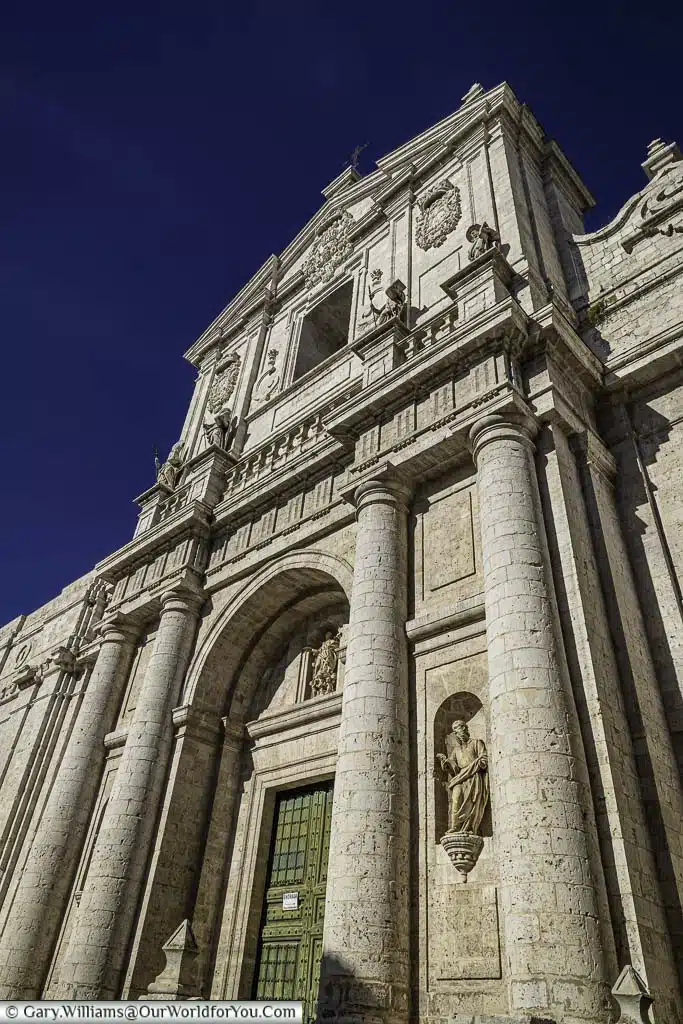 Looking up to the façade of valladolid cathedral under a deep blue sky in the castile and león region of spain